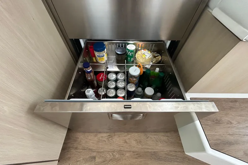 Slide: The Image of Open drawer refrigerator on 2023 Regal 38 FXO yacht, stocked with beverages and condiments. - 84