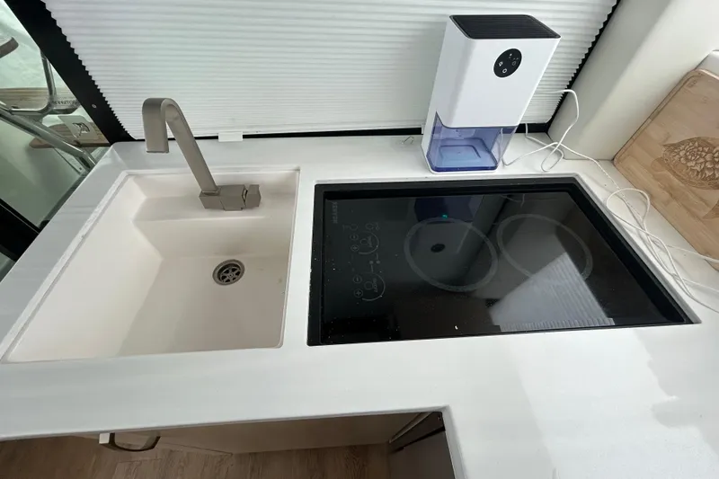 Slide: The Image of Modern kitchen area in 2023 Regal 38 FXO yacht with sink and induction cooktop. - 86