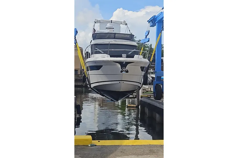 Slide: The Image of 2023 Regal 38 FXO yacht being lifted at a marina. - 9