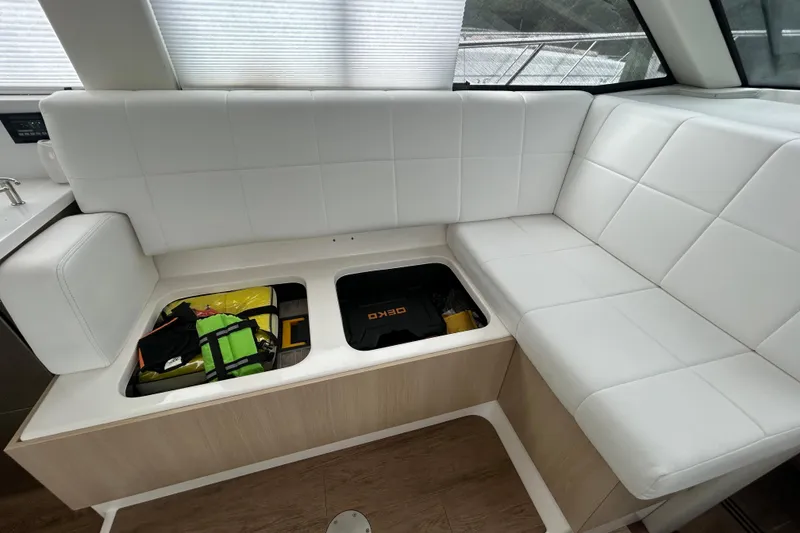 Slide: The Image of White leather seating with under-seat storage on 2023 Regal 38 FXO boat. - 90