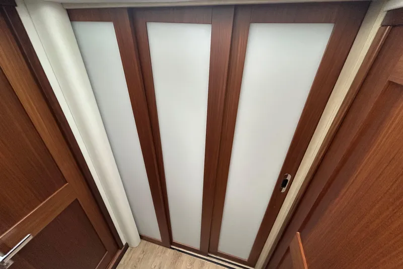 Slide: The Image of Sliding wooden door with frosted panels inside a 2023 Regal 38 FXO boat. - 93