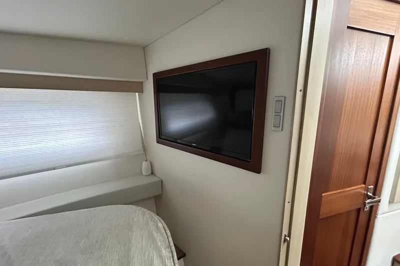 Slide: The Image of Interior of 2023 Regal 38 FXO yacht with wall-mounted TV and wooden door. - 96