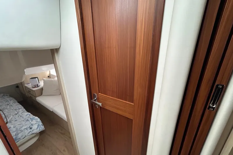 Slide: The Image of Interior of 2023 Regal 38 FXO yacht, featuring a cozy cabin with wooden door. - 99