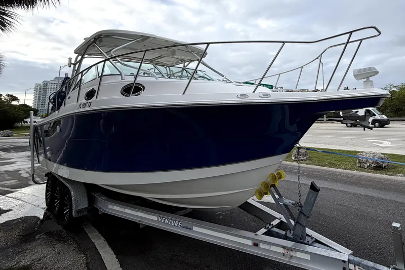 Slide: The Image of 2001 Wellcraft 290 Coastal boat on trailer, parked near road with overcast sky. - 16