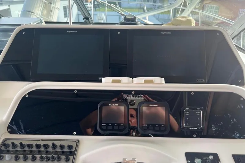 Slide: The Image of 2001 Wellcraft 290 Coastal boat on trailer, parked near palm trees. - 2