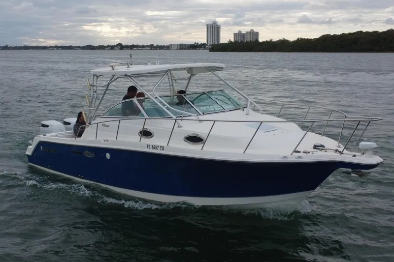 Slide: The Image of 2001 Wellcraft 290 Coastal boat on water with city skyline in background. - 24
