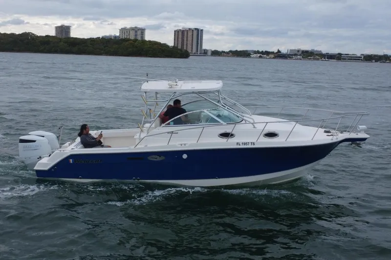 Slide: The Image of 2001 Wellcraft 290 Coastal boat on water with two people. - 25