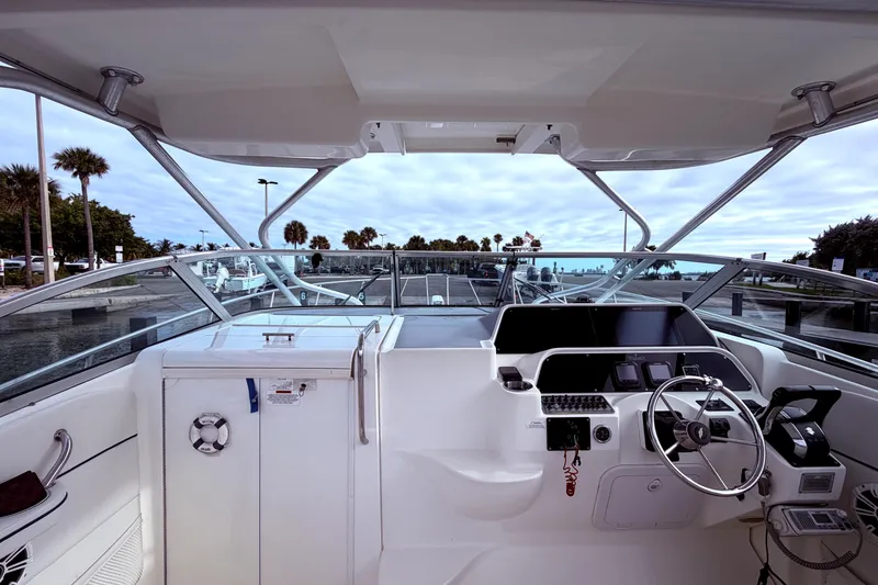 Slide: The Image of 2001 Wellcraft 290 Coastal boat cockpit with steering wheel, dashboard, and marina view. - 34