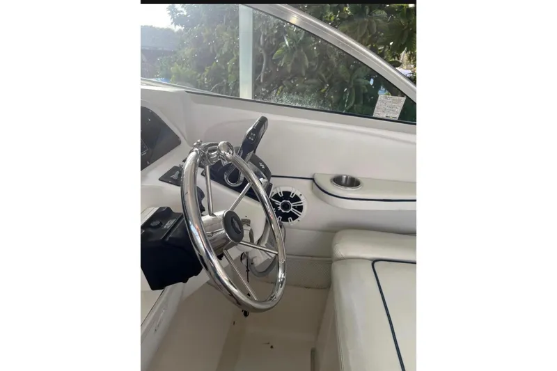 Slide: The Image of 2001 Wellcraft 290 Coastal boat with Suzuki outboard motor, parked near palm trees. - 4