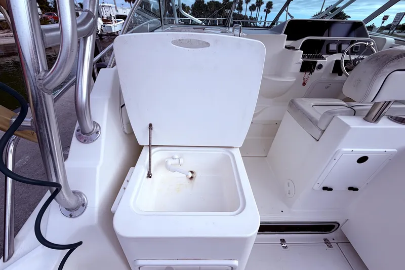 Slide: The Image of 2001 Wellcraft 290 Coastal boat interior with open storage compartment and steering area. - 42