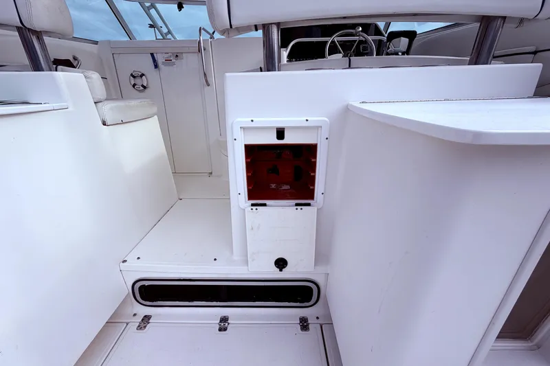 Slide: The Image of 2001 Wellcraft 290 Coastal boat interior with white seating and control panel. - 43
