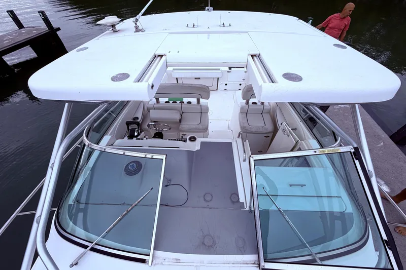 Slide: The Image of 2001 Wellcraft 290 Coastal boat docked, showcasing spacious cockpit and seating area. - 54