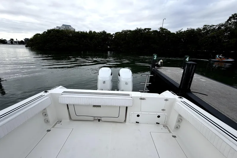 Slide: The Image of 2001 Wellcraft 290 Coastal boat docked, featuring dual outboard engines and spacious deck. - 57