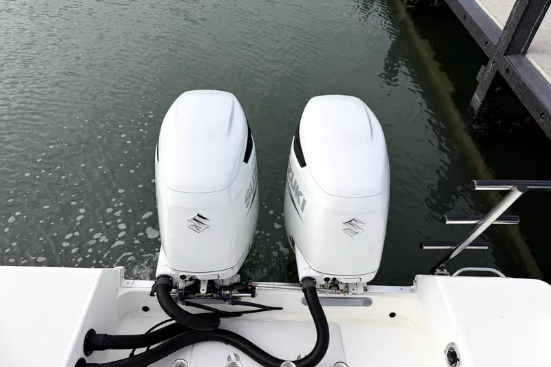 Slide: The Image of Twin Suzuki outboard motors on a 2001 Wellcraft 290 Coastal boat at dock. - 58