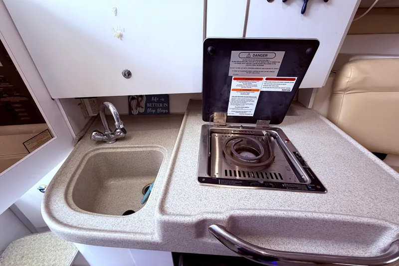 Slide: The Image of 2001 Wellcraft 290 Coastal boat kitchen with sink and stove. - 73