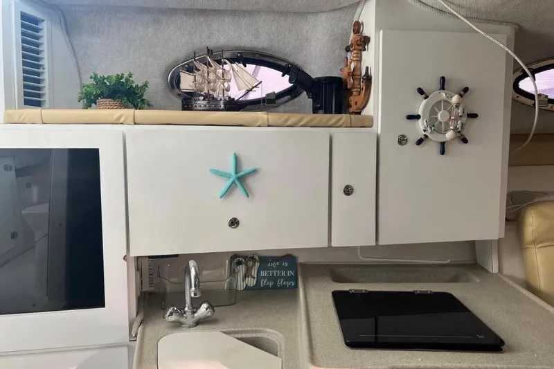 Slide: The Image of Interior of 2001 Wellcraft 290 Coastal boat with nautical decor and compact kitchen area. - 74