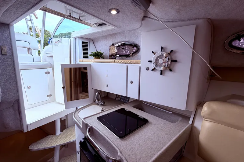 Slide: The Image of Interior of 2001 Wellcraft 290 Coastal boat, featuring compact kitchen and seating area. - 75
