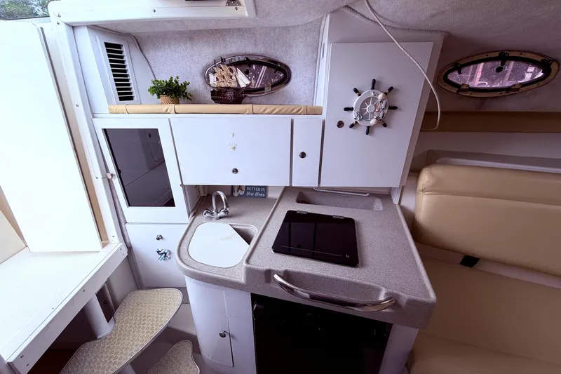 Slide: The Image of 2001 Wellcraft 290 Coastal boat interior with kitchenette, sink, and nautical decor. - 76