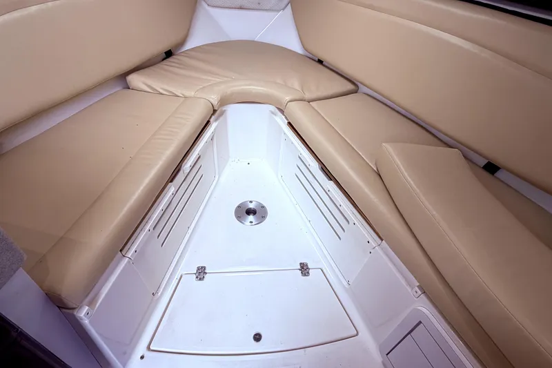 Slide: The Image of 2001 Wellcraft 290 Coastal cabin interior with beige seating and storage compartments. - 84