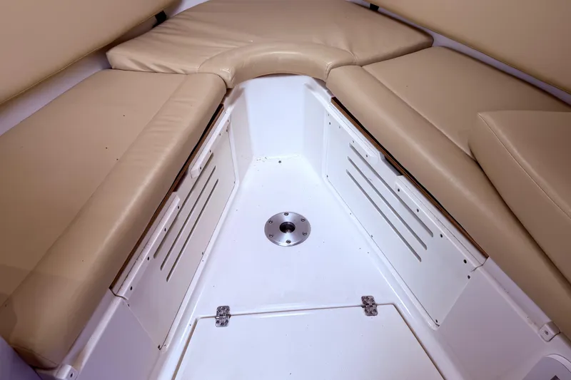 Slide: The Image of 2001 Wellcraft 290 Coastal interior with beige cushioned seating and storage compartments. - 85