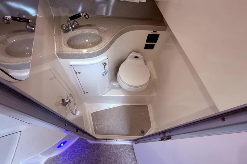 Slide: The Image of 2001 Wellcraft 290 Coastal boat bathroom with sink, toilet, and compact design. - 88
