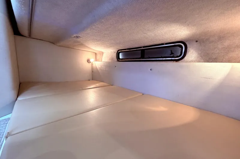 Slide: The Image of 2001 Wellcraft 290 Coastal cabin interior with beige cushions and ambient lighting. - 90