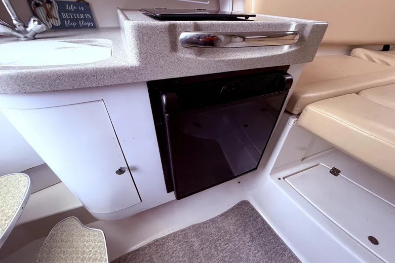Slide: The Image of Interior of 2001 Wellcraft 290 Coastal boat, featuring kitchenette and seating area. - 93