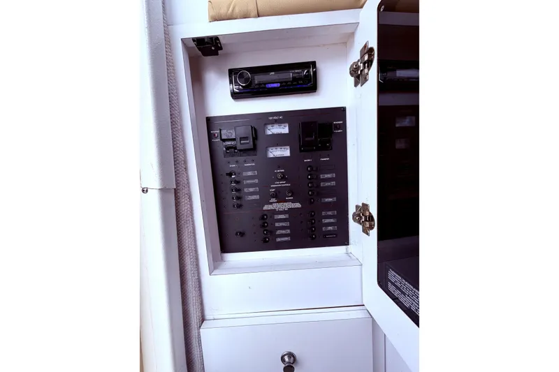 Slide: The Image of Electrical panel inside 2001 Wellcraft 290 Coastal boat, featuring control switches and stereo system. - 96