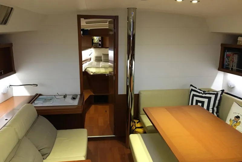 Slide: The Image of Interior of 2013 Beneteau Oceanis 45 yacht, featuring cozy seating and elegant wood finishes. - 4