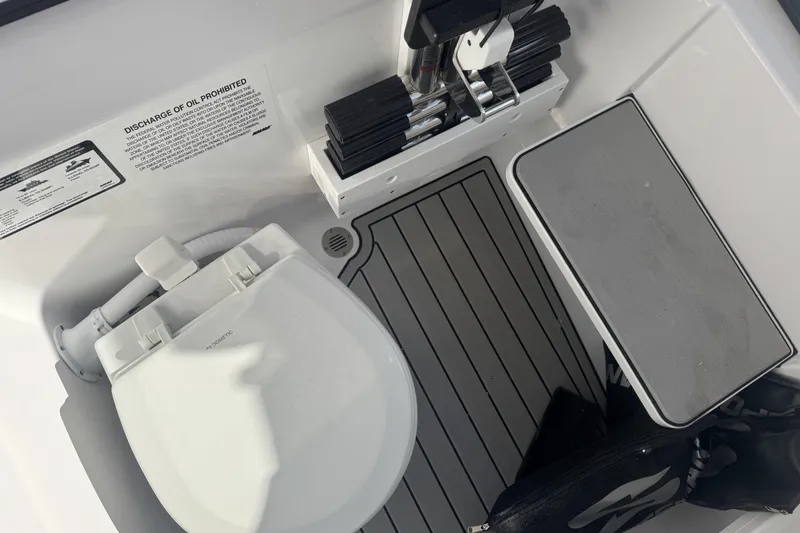 Slide: The Image of 2026 Sportsman Open 282 Center Console boat toilet area with storage and equipment. - 17