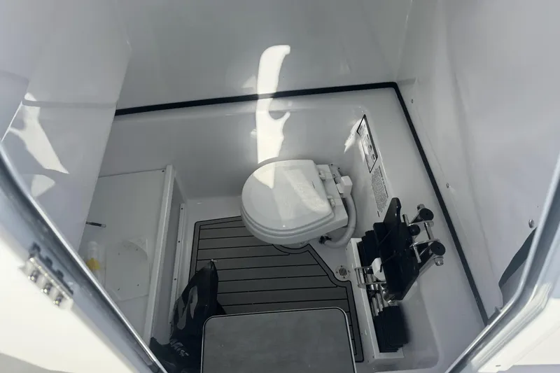 Slide: The Image of 2026 Sportsman Open 282 Center Console boat interior with compact marine toilet. - 18