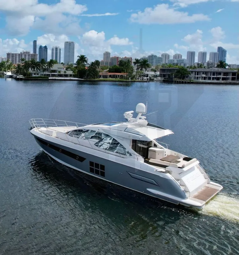 Slide: The Image of 2015 Azimut 55S yacht cruising on a scenic waterfront with city skyline. - 3