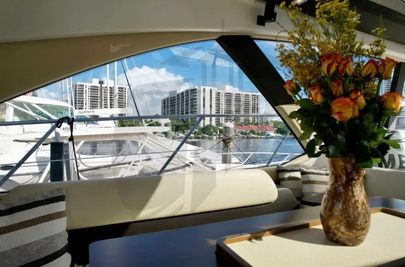 Slide: The Image of Interior view of 2015 Azimut 55S yacht with floral arrangement and marina backdrop. - 34