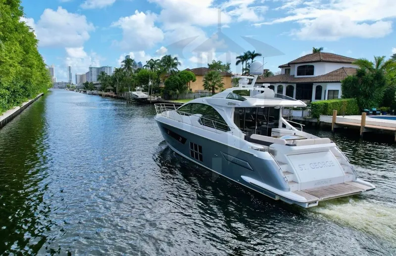 Slide: The Image of Azimut 55S 2015 yacht cruising on a scenic canal with luxury homes. - 5