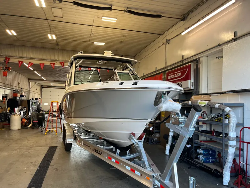 Slide: The Image of 2025 Boston Whaler 28 Vantage in a workshop on a trailer. - 28