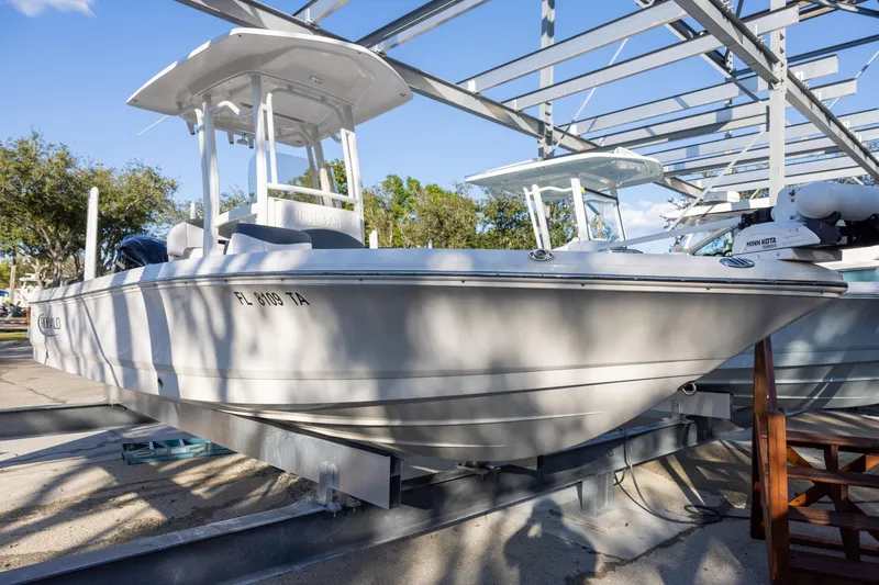 Slide: The Image of 2021 Robalo 226 Cayman boat on display in a marina setting. - 1