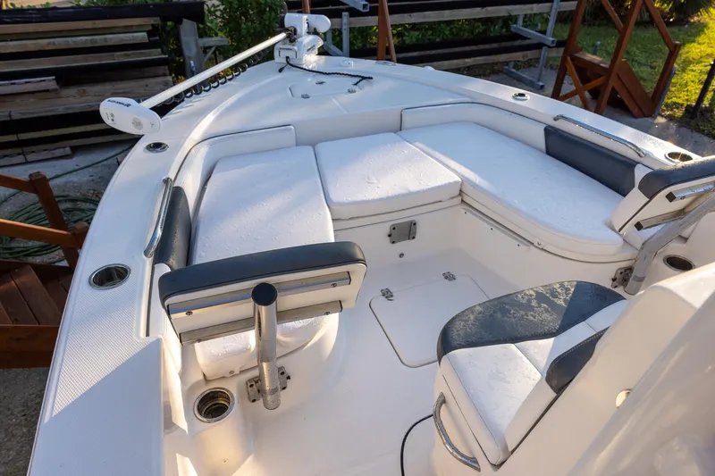 Slide: The Image of 2021 Robalo 226 Cayman boat interior with cushioned seating and fishing rod holders. - 13