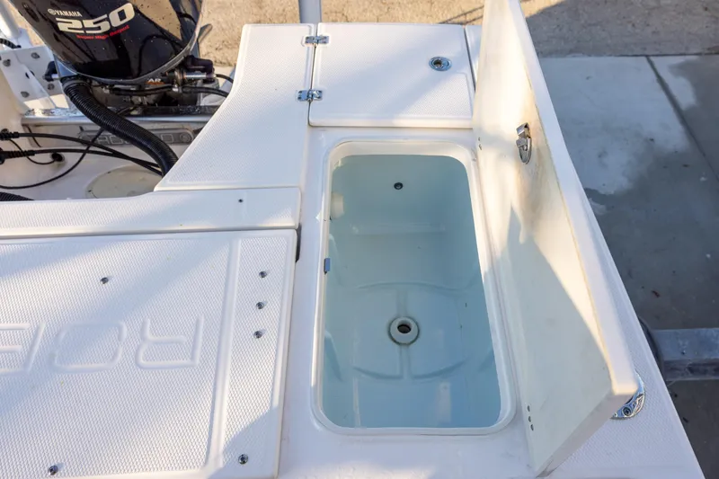 Slide: The Image of 2021 Robalo 226 Cayman boat with open storage compartment and Yamaha 250 engine. - 8
