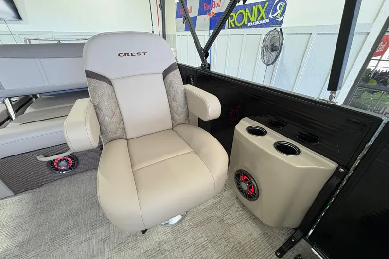 Slide: The Image of 2025 Crest Classic 220 boat interior with beige captain's chair and cup holders. - 10