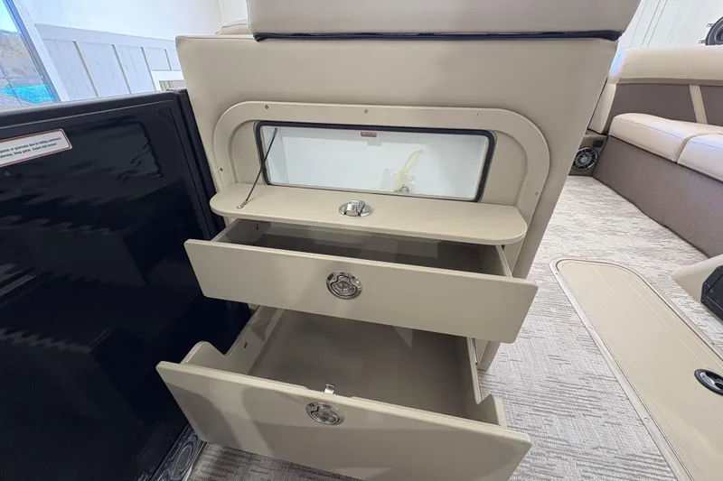 Slide: The Image of 2025 Crest Classic 220 interior storage drawers in a luxury boat setting. - 20