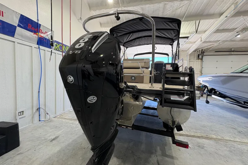 Slide: The Image of 2025 Crest Classic 220 pontoon boat with powerful outboard motor in a garage setting. - 4