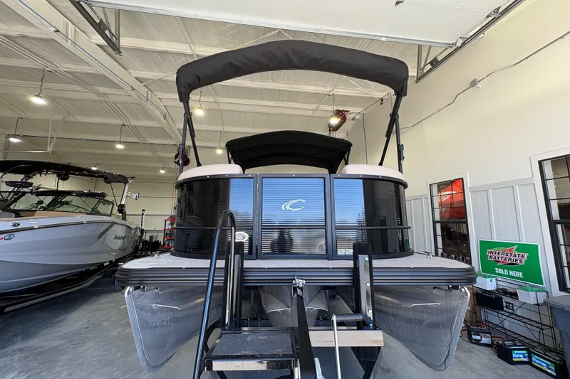 Slide: The Image of 2025 Crest Classic 220 pontoon boat in showroom, featuring sleek design and modern amenities. - 9