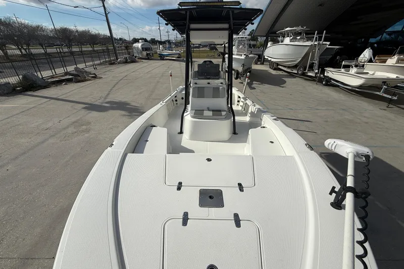 Slide: The Image of 2009 BlackJack 224 boat on display at a marina, showcasing spacious deck and seating. - 11