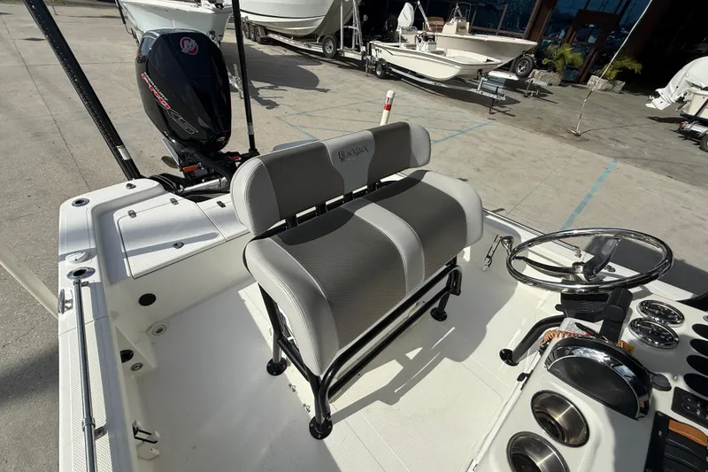 Slide: The Image of 2009 BlackJack 224 boat interior with seating and steering wheel, docked outdoors. - 13