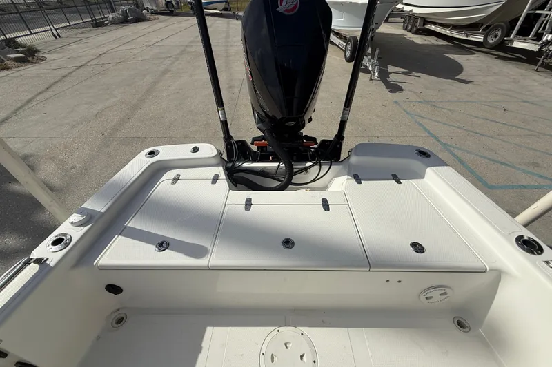 Slide: The Image of 2009 BlackJack 224 boat deck with motor, docked in a marina. - 14