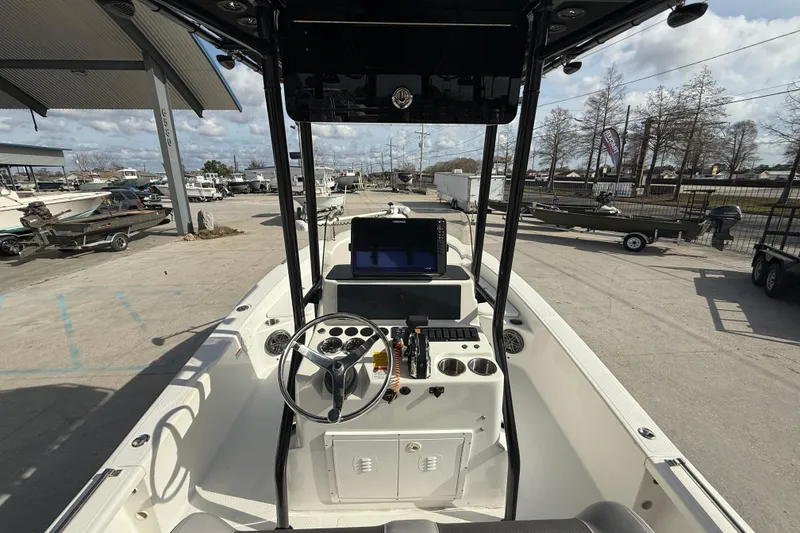 Slide: The Image of 2009 BlackJack 224 boat interior with steering wheel and control panel at a marina. - 16