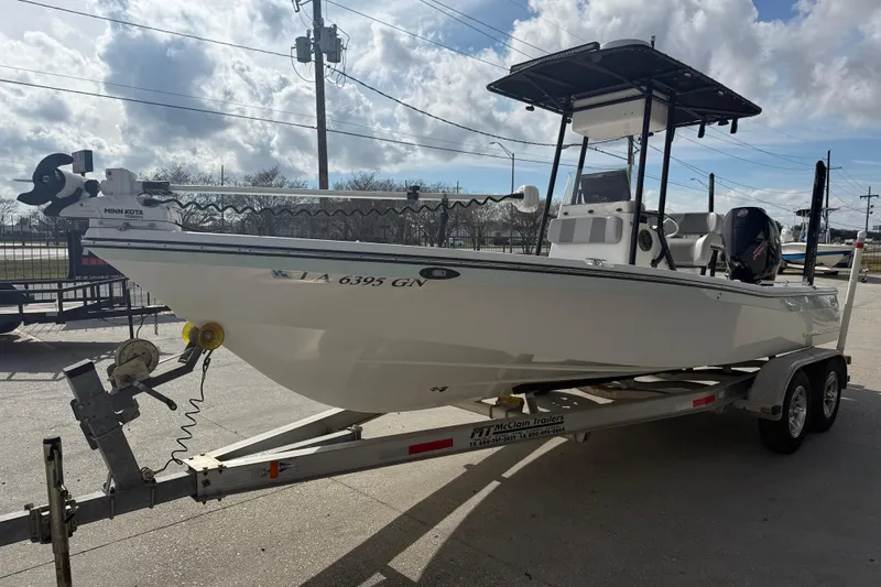 Slide: The Image of 2009 BlackJack 224 boat on trailer, featuring Minn Kota trolling motor, under cloudy sky. - 4