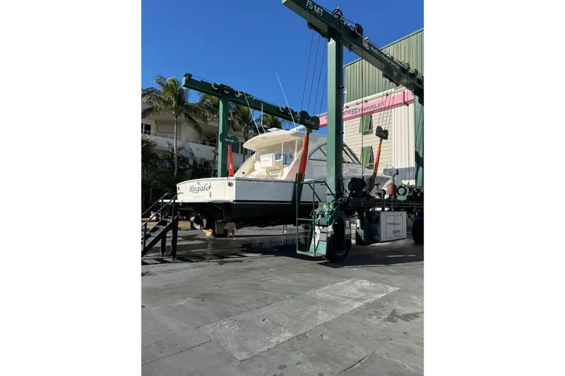 Slide: The Image of 2013 Cabo 44 Hardtop Express yacht on lift at marina. - 109