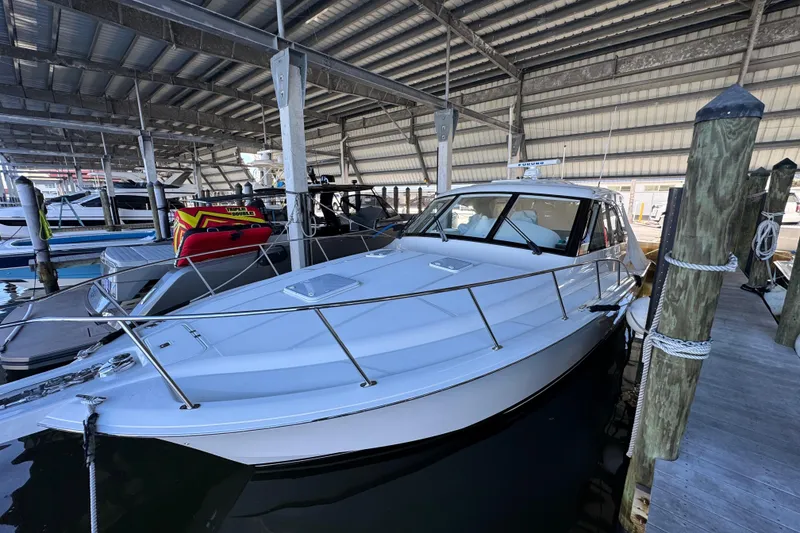 The Image of 2013 Cabo 44 Hardtop Express yacht docked in a covered marina. - 20