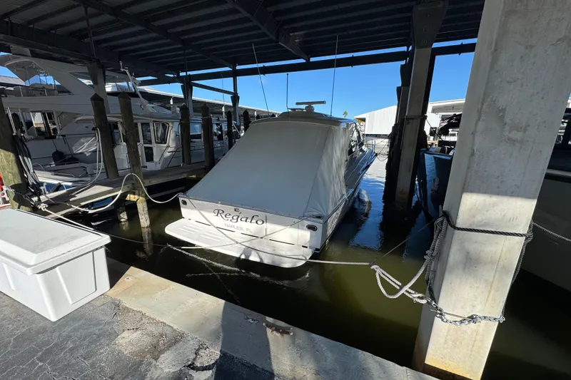 Slide: The Image of 2013 Cabo 44 Hardtop Express docked in covered marina slip. - 22